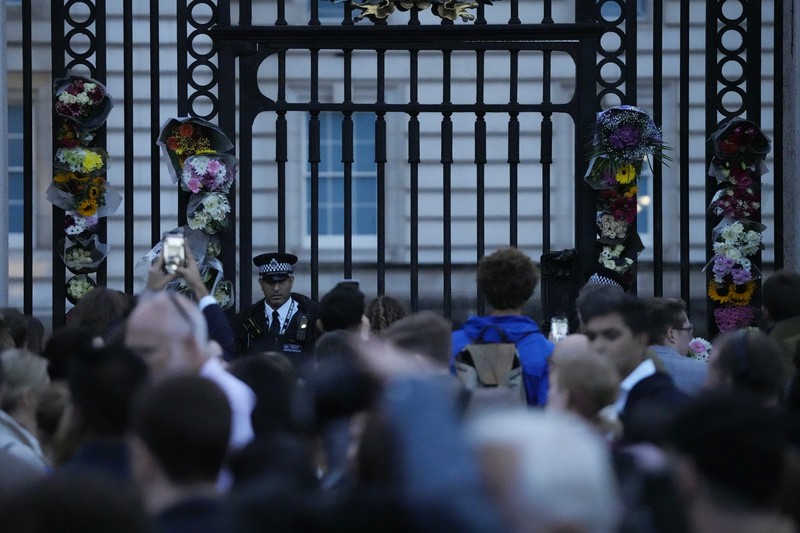 Pengumuman meninggalnya Ratu Elizabeth di pagar di luar Istana Buckingham, London, Inggris Personil menempatkan tanda yang mengumumkan meninggalnya Ratu Elizabeth di pagar di luar Istana Buckingham, London, Inggris, Kamis (8/9/2022). Ratu Elizabeth yang merupakan raja terlama yang memerintah Inggris dan tokoh negara selama tujuh dekade meninggal dalam usia 96 tahun.( REUTERS/Henry Nicholls)