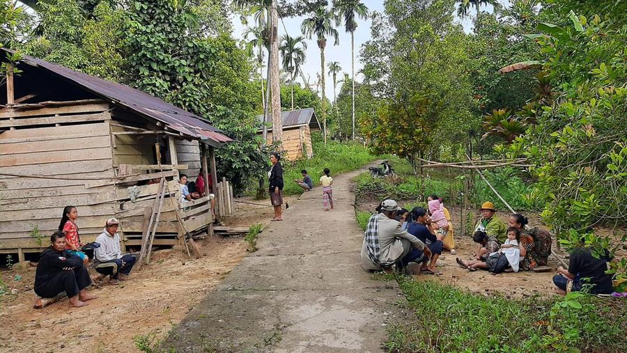 Warga berkumpul di luar rumah mereka setelah gempa bumi di Kepulauan Mentawai Indonesia, di desa Muara Sikabaluan di Siberut Utara, provinsi Sumatera Barat, Minggu (11/9/2022). (Photo by BAMBANG SAGURUNG/AFP via Getty Images)
