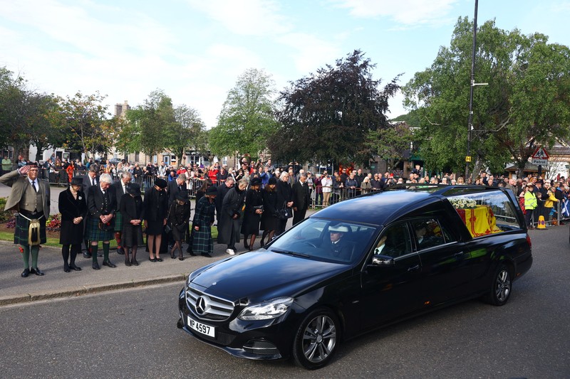 Mobil jenazah yang membawa peti mati Ratu Elizabeth Inggris meninggalkan Kastil Balmoral, di Balmoral, Skotlandia, Inggris ke Istana Holyroodhouse di Edinburgh Mobil jenazah membawa peti mati Ratu Elizabeth II yang ditutupi Standar Kerajaan untuk Skotlandia dan karangan bunga meninggalkan Kastil Balmoral, di Balmoral, Skotlandia, Inggris, Minggu (11/9/2022). Peti mati ratu akan dibawa sejauh 290 km melalui jalan darat dari perkebunan terpencil ke Istana Holyroodhouse di Edinburgh. (Photo by Owen Humphreys/PA Images via Getty Images)