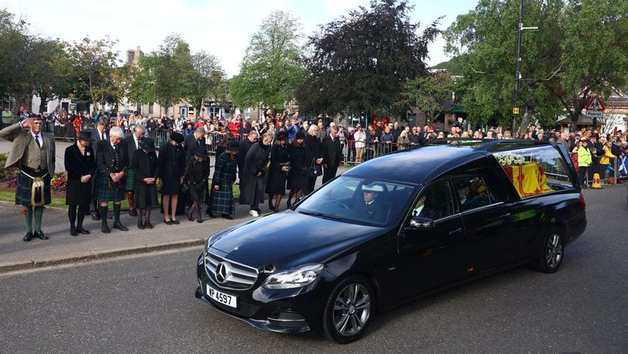 Mobil jenazah membawa peti mati Ratu Elizabeth II yang ditutupi Standar Kerajaan untuk Skotlandia dan karangan bunga meninggalkan Kastil Balmoral, di Balmoral, Skotlandia, Inggris, Minggu (11/9/2022). Peti mati ratu akan dibawa sejauh 290 km melalui jalan darat dari perkebunan terpencil ke Istana Holyroodhouse di Edinburgh. (Photo by Owen Humphreys/PA Images via Getty Images)