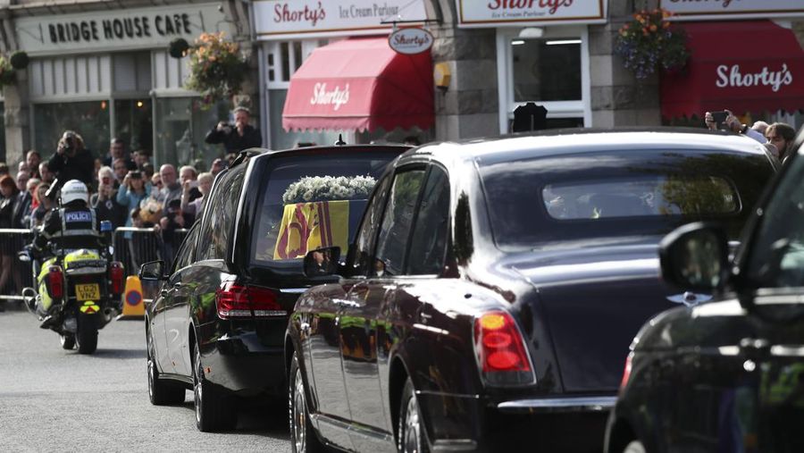 Mobil jenazah membawa peti mati Ratu Elizabeth II yang ditutupi Standar Kerajaan untuk Skotlandia dan karangan bunga meninggalkan Kastil Balmoral, di Balmoral, Skotlandia, Inggris, Minggu (11/9/2022). Peti mati ratu akan dibawa sejauh 290 km melalui jalan darat dari perkebunan terpencil ke Istana Holyroodhouse di Edinburgh. (Photo by Owen Humphreys/PA Images via Getty Images)