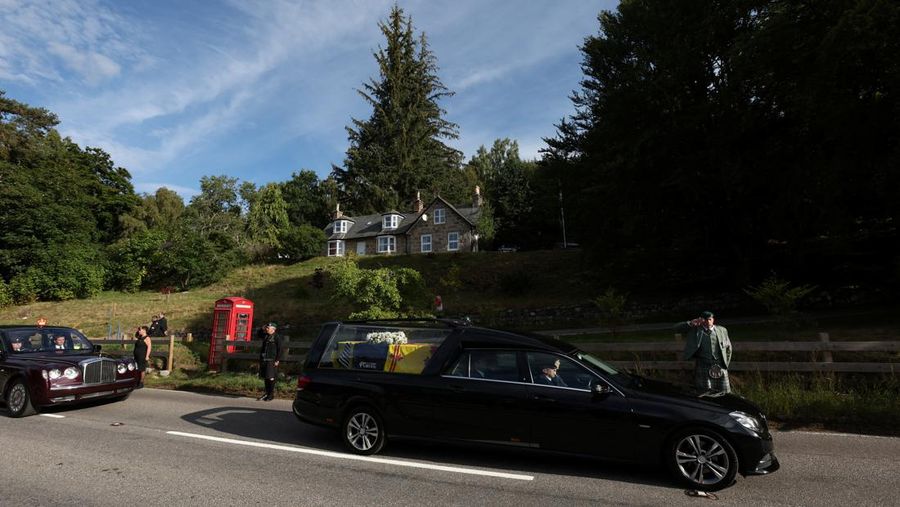 Mobil jenazah membawa peti mati Ratu Elizabeth II yang ditutupi Standar Kerajaan untuk Skotlandia dan karangan bunga meninggalkan Kastil Balmoral, di Balmoral, Skotlandia, Inggris, Minggu (11/9/2022). Peti mati ratu akan dibawa sejauh 290 km melalui jalan darat dari perkebunan terpencil ke Istana Holyroodhouse di Edinburgh. (Photo by Owen Humphreys/PA Images via Getty Images)