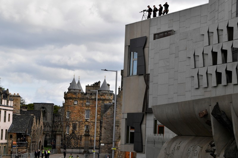 Police officers with snipers stand on the roof of the St Giles' Cathedral in Edinburgh on September 11, 2022, where Queen Elizabeth II will lie at rest and ahead of the ceremony of the proclamation of Britain's King Charles III. - Queen Elizabeth II's coffin will travel by road through Scottish towns and villages on Sunday as it begins its final journey from her beloved Scottish retreat of Balmoral. The Queen, who died on September 8, will be taken to the Palace of Holyroodhouse before lying at rest in St Giles' Cathedral, before travelling onwards to London for her funeral. (Photo by Oli SCARFF / AFP) (Photo by OLI SCARFF/AFP via Getty Images)