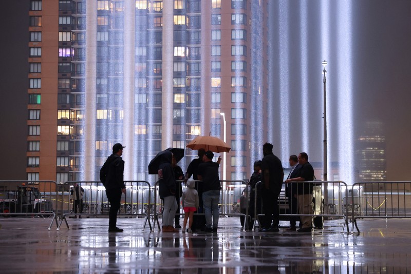 A person looks toward the Tribute in Light for the remembrance of the 21st anniversary of the September 11, 2001 attacks in Manhattan, New York City, U.S., September 11, 2022.  REUTERS/Andrew Kelly