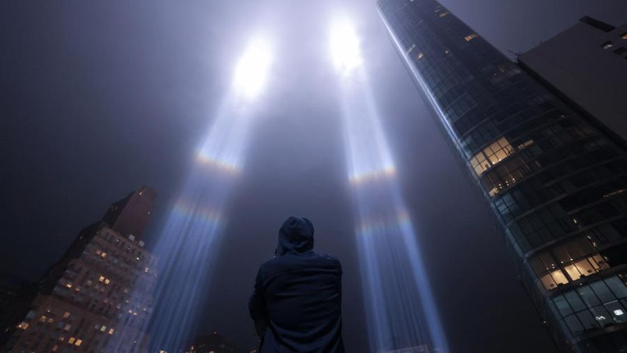 A person looks toward the Tribute in Light for the remembrance of the 21st anniversary of the September 11, 2001 attacks in Manhattan, New York City, U.S., September 11, 2022.  REUTERS/Andrew Kelly