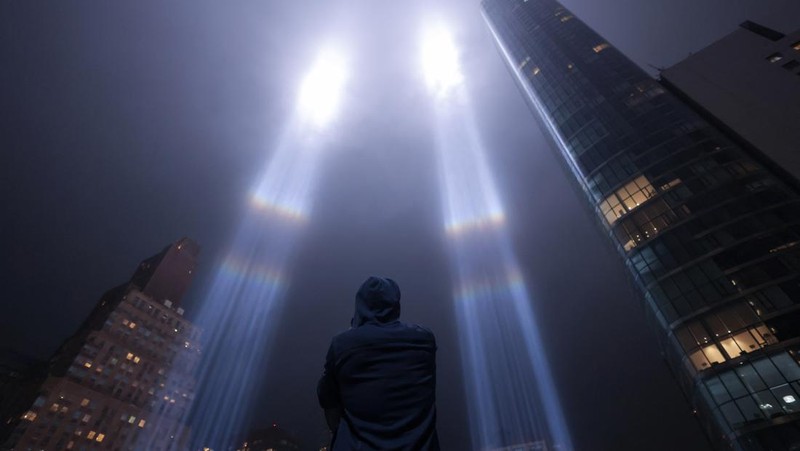 A person looks toward the Tribute in Light for the remembrance of the 21st anniversary of the September 11, 2001 attacks in Manhattan, New York City, U.S., September 11, 2022.  REUTERS/Andrew Kelly