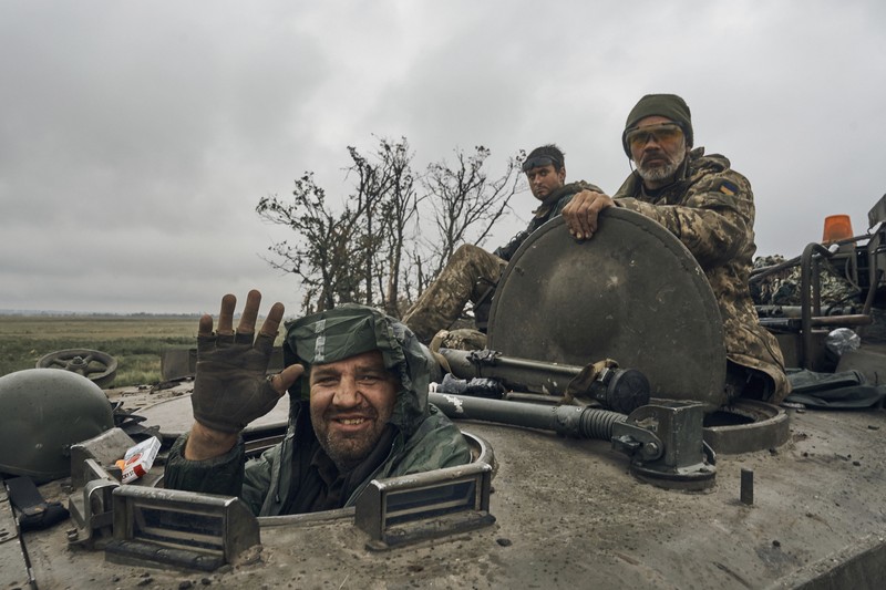 APTOPIX Russia Ukraine War A Ukrainian soldier smiles from a military vehicle on the road in the freed territory in the Kharkiv region, Ukraine, Monday, Sept. 12, 2022. Ukrainian troops retook a wide swath of territory from Russia on Monday, pushing all the way back to the northeastern border in some places, and claimed to have captured many Russian soldiers as part of a lightning advance that forced Moscow to make a hasty retreat. (AP Photo/Kostiantyn Liberov)