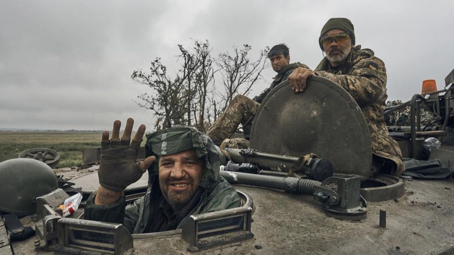 A Ukrainian soldier smiles from a military vehicle on the road in the freed territory in the Kharkiv region, Ukraine, Monday, Sept. 12, 2022. Ukrainian troops retook a wide swath of territory from Russia on Monday, pushing all the way back to the northeastern border in some places, and claimed to have captured many Russian soldiers as part of a lightning advance that forced Moscow to make a hasty retreat. (AP Photo/Kostiantyn Liberov)