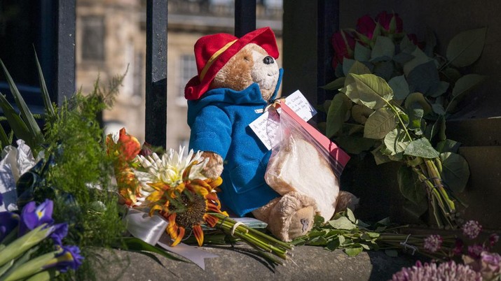 A Paddington Bear toy and marmalade sandwich is left amongst flowers and tributes outside the Palace of Holyroodhouse, following the death of Queen Elizabeth II on Thursday, in Edinburgh, Saturday, Sept. 10, 2022. Queen Elizabeth II, Britain's longest-reigning monarch and a rock of stability across much of a turbulent century, died Thursday after 70 years on the throne. She was 96. (Jane Barlow/PA via AP)