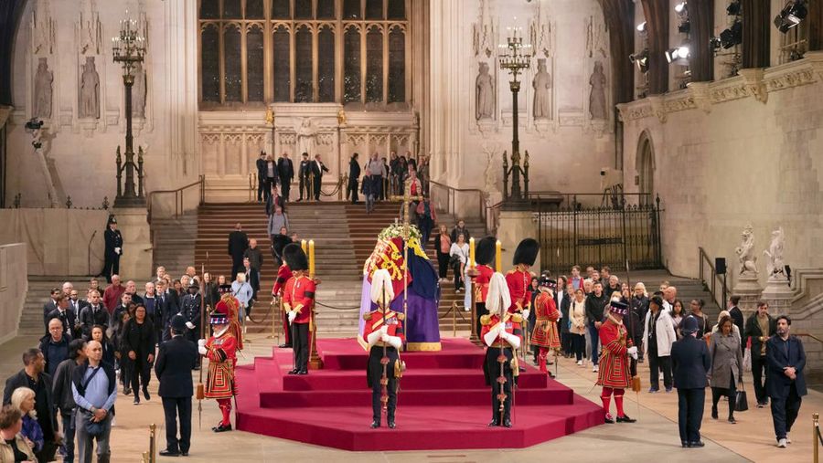 Members of the public file past the coffin of Queen Elizabeth II, draped in the Royal Standard with the Imperial State Crown and the Sovereign's orb and sceptre, lying in state on the catafalque in Westminster Hall, at the Palace of Westminster, in London, Thursday, Sept. 15, 2022, ahead of her funeral on Monday. (Danny Lawson/Pool Photo via AP)