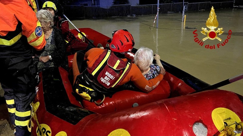 Rescue workers arrive on a dinghy boat on a flooded street after heavy rains hit the east coast of Marche region in Senigallia, Italy, September 16, 2022. Vigili del Fuoco/Handout via REUTERS ATTENTION EDITORS THIS IMAGE HAS BEEN SUPPLIED BY A THIRD PARTY. DO NOT OBSCURE LOGO.