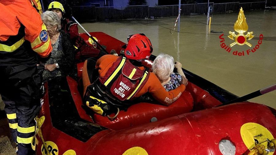 Rescue workers arrive on a dinghy boat on a flooded street after heavy rains hit the east coast of Marche region in Senigallia, Italy, September 16, 2022. Vigili del Fuoco/Handout via REUTERS ATTENTION EDITORS THIS IMAGE HAS BEEN SUPPLIED BY A THIRD PARTY. DO NOT OBSCURE LOGO.