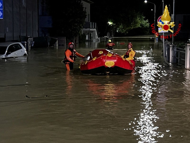 Rescue workers arrive on a dinghy boat on a flooded street after heavy rains hit the east coast of Marche region in Senigallia, Italy, September 16, 2022. Vigili del Fuoco/Handout via REUTERS ATTENTION EDITORS THIS IMAGE HAS BEEN SUPPLIED BY A THIRD PARTY. DO NOT OBSCURE LOGO.