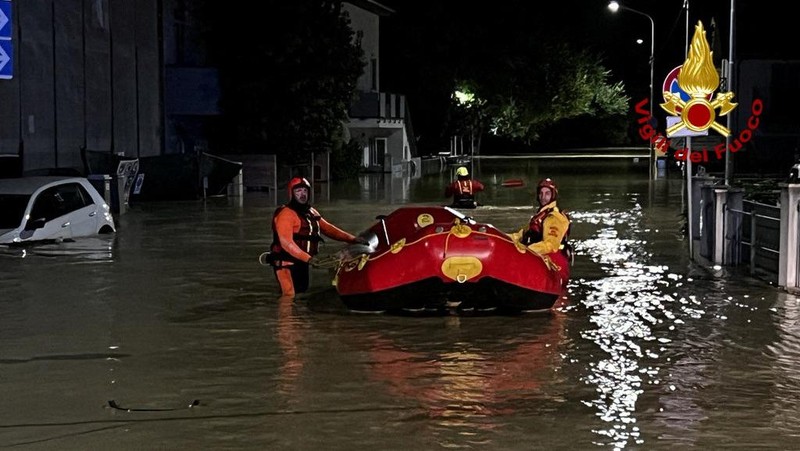 Rescue workers arrive on a dinghy boat on a flooded street after heavy rains hit the east coast of Marche region in Senigallia, Italy, September 16, 2022. Vigili del Fuoco/Handout via REUTERS ATTENTION EDITORS THIS IMAGE HAS BEEN SUPPLIED BY A THIRD PARTY. DO NOT OBSCURE LOGO.