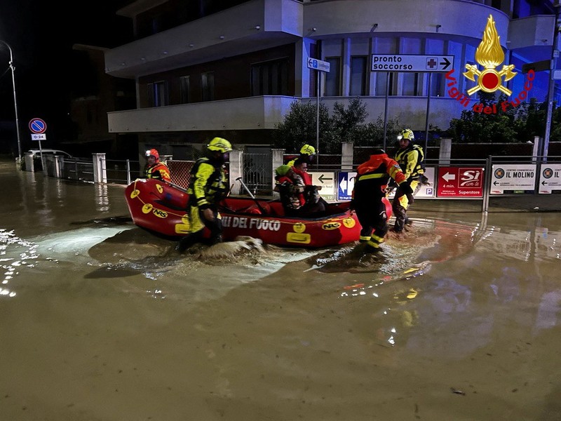 EUROPE-WEATHER/ITALY-FLOODS Rescue workers arrive on a dinghy boat on a flooded street after heavy rains hit the east coast of Marche region in Senigallia, Italy, September 16, 2022. Vigili del Fuoco/Handout via REUTERS ATTENTION EDITORS THIS IMAGE HAS BEEN SUPPLIED BY A THIRD PARTY. DO NOT OBSCURE LOGO.