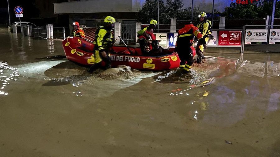 Rescue workers arrive on a dinghy boat on a flooded street after heavy rains hit the east coast of Marche region in Senigallia, Italy, September 16, 2022. Vigili del Fuoco/Handout via REUTERS ATTENTION EDITORS THIS IMAGE HAS BEEN SUPPLIED BY A THIRD PARTY. DO NOT OBSCURE LOGO.
