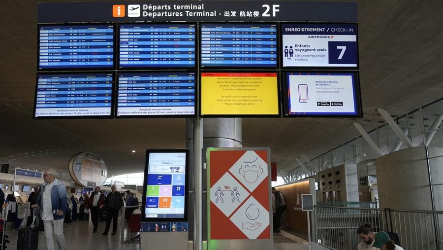 A traveler pulls her trolley Friday, Sept. 16, 2022 at Roissy Charles de Gaulle airport, north of Paris. Many domestic and some international flights were canceled in France Friday as air traffic controllers went on a national strike over pay and recruitment issues. French civil aviation authority DGAC warned that domestic traffic would be 