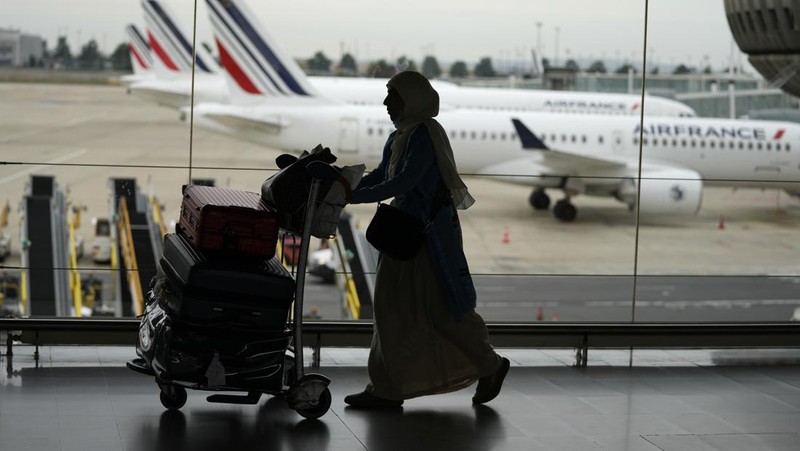 A traveler pulls her trolley Friday, Sept. 16, 2022 at Roissy Charles de Gaulle airport, north of Paris. Many domestic and some international flights were canceled in France Friday as air traffic controllers went on a national strike over pay and recruitment issues. French civil aviation authority DGAC warned that domestic traffic would be 