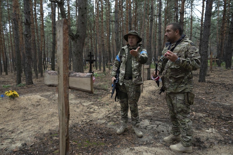 Russia Ukraine War A view of unidentified graves of civilians and Ukrainian soldiers in a cemetery in the recently retaken area of Izium, Ukraine, Thursday, Sept. 15, 2022 who had been killed by Russian forces near the beginning of the war. A mass grave of Ukrainian soldiers and unknown buried civilians was found in the forest of recently recaptured city of Izium. (AP Photo/Evgeniy Maloletka)