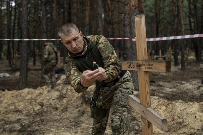 A view of unidentified graves of civilians and Ukrainian soldiers in a cemetery in the recently retaken area of Izium, Ukraine, Thursday, Sept. 15, 2022 who had been killed by Russian forces near the beginning of the war. A mass grave of Ukrainian soldiers and unknown buried civilians was found in the forest of recently recaptured city of Izium. (AP Photo/Evgeniy Maloletka)