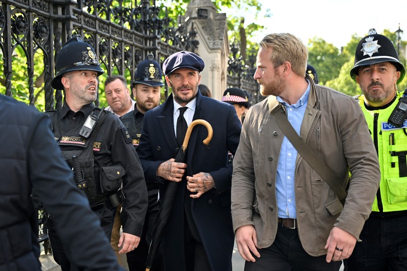 Mantan pemain sepak bola Inggris David Beckham (belakang C) meninggalkan Westminster Hall, di Istana Westminster, di London pada 16 September 2022 setelah memberikan penghormatan kepada peti mati Ratu Elizabeth II