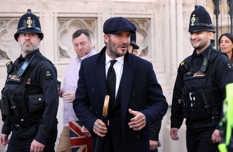 Mantan pemain sepak bola Inggris David Beckham (belakang C) meninggalkan Westminster Hall, di Istana Westminster, di London pada 16 September 2022 setelah memberikan penghormatan kepada peti mati Ratu Elizabeth II