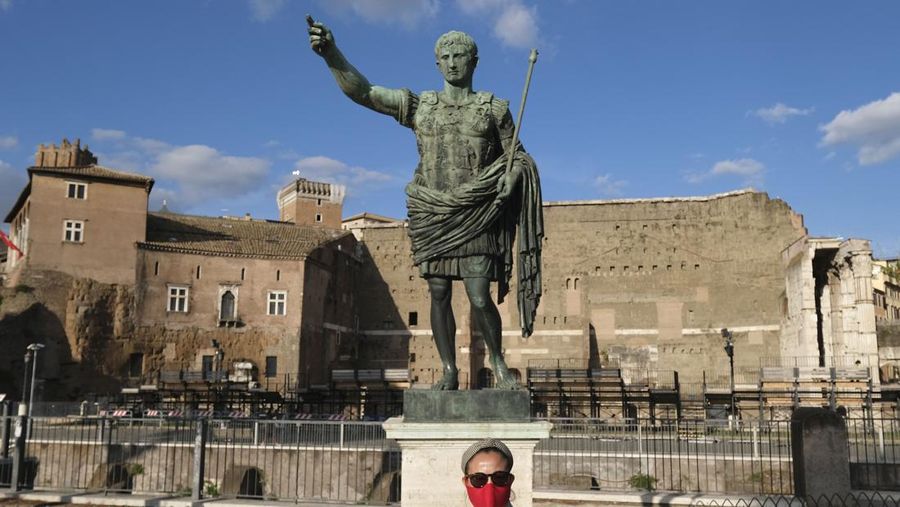 ROME, ITALY - SEPTEMBER 29: A woman walks past a statue of Roman emperor Caesar Augustus on September 30, 2020 in downtown Rome, Italy.  Italy is likely to extend a state of emergency to help keep the coronavirus crisis under control as the government looks to avoid the surge in new cases hitting other European countries. Picture taken September 29, 2020. (Photo by Max Rossi/Getty Images)