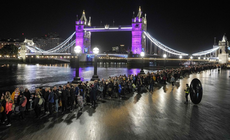 Britain Royals People queue in front of Tower Bridge to pay their respect to the late Queen Elizabeth II during the Lying-in State at Westminster Hall in London, early Saturday morning, Sept. 17, 2022. The Queen will lie in state in Westminster Hall for four full days before her funeral on Monday Sept. 19. (AP Photo/Martin Meissner)