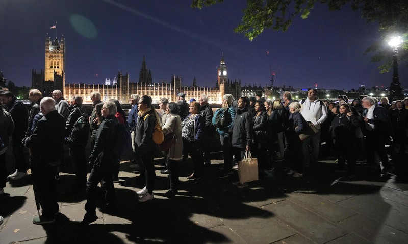 Britain Royals People queue in front of Tower Bridge to pay their respect to the late Queen Elizabeth II during the Lying-in State at Westminster Hall in London, early Saturday morning, Sept. 17, 2022. The Queen will lie in state in Westminster Hall for four full days before her funeral on Monday Sept. 19. (AP Photo/Martin Meissner)