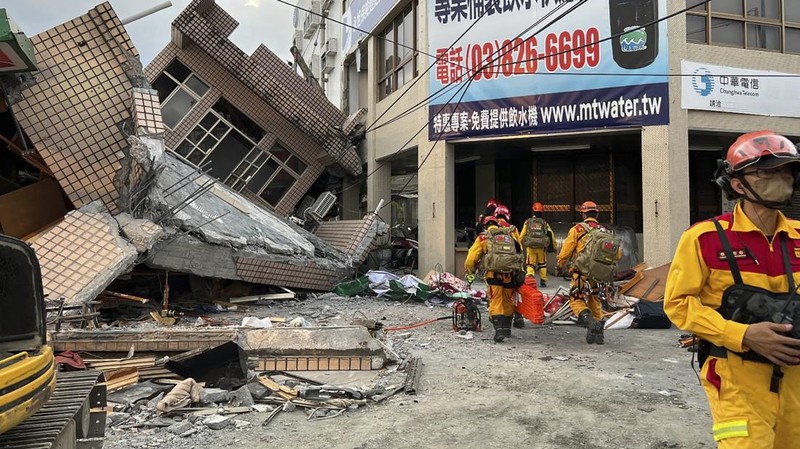 Petugas pemadam kebakaran dalam mencari korban yang terperangkap di sebuah bangunan perumahan yang runtuh setelah gempa bumi di kotapraja Yuli di Kabupaten Hualien, Taiwan timur, Minggu, 18 September 2022. (Hualien City Government via AP)