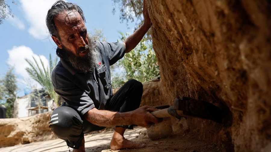 Petani Palestina Salman al-Nabahin membersihkan lantai mosaik yang ia temukan di pertaniannya dan berasal dari era Bizantium, menurut para pejabat, di Jalur Gaza tengah 18 September 2022. (REUTERS/IBRAHEEM ABU MUSTAFA)