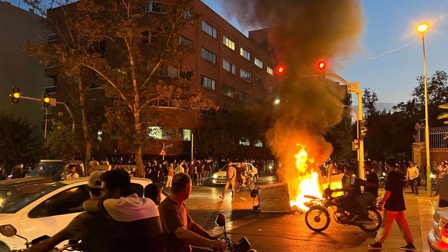 Demonstran berkumpul di sekitar barikade yang terbakar selama protes untuk Mahsa Amini. (AFP via Getty Images)