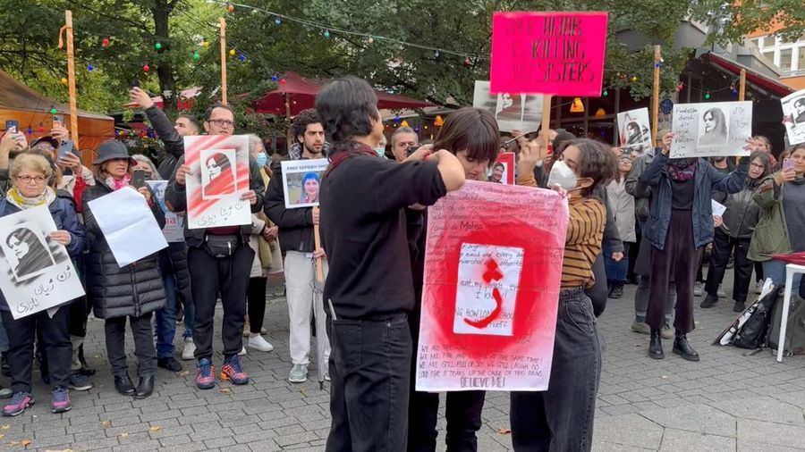 Demonstran memotong rambut mereka saat protes solidaritas dengan perempuan di Iran. (via REUTERS/VIDEO OBTAINED BY REUTERS)