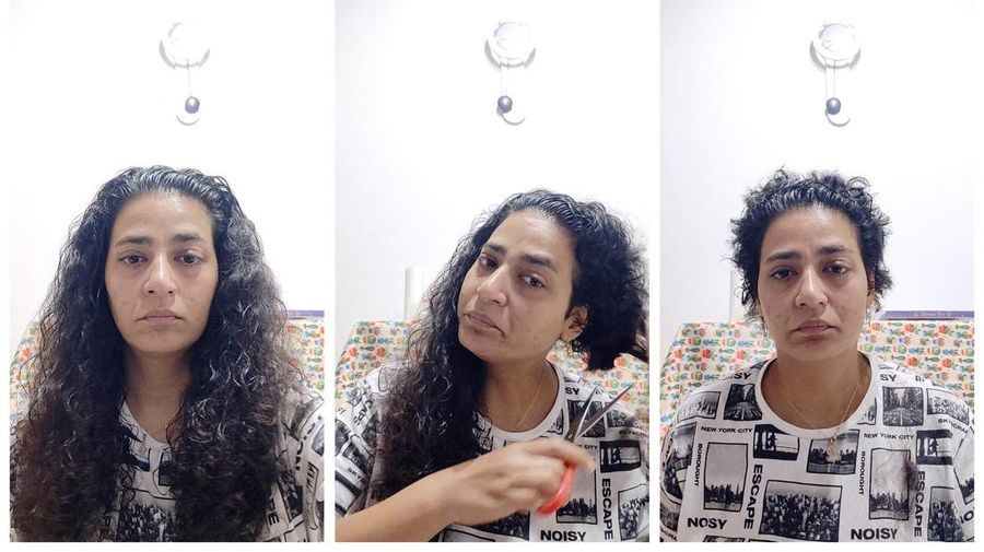 Seorang wanita memotong rambutnya sebagai protes menyusul kematian wanita Iran Mahsa Amini dalam tahanan polisi. (Faezeh Afshan via REUTERS/FAEZEH AFSHAN)