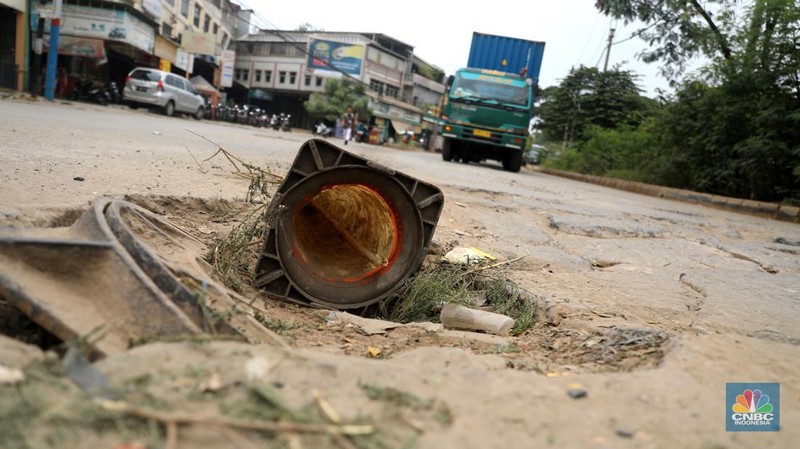 Sejumlah kendaraan melintas di jalan yang rusak di Kawasan Jalan raya Perancis Dadap, Tangerang Kamis, (22/9/2022). (CNBC Indonesia/Muhammad Sabki)