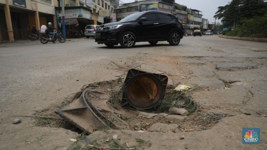 Sejumlah kendaraan melintas di jalan yang rusak di Kawasan Jalan raya Perancis Dadap, Tangerang Kamis, (22/9/2022). (CNBC Indonesia/Muhammad Sabki)