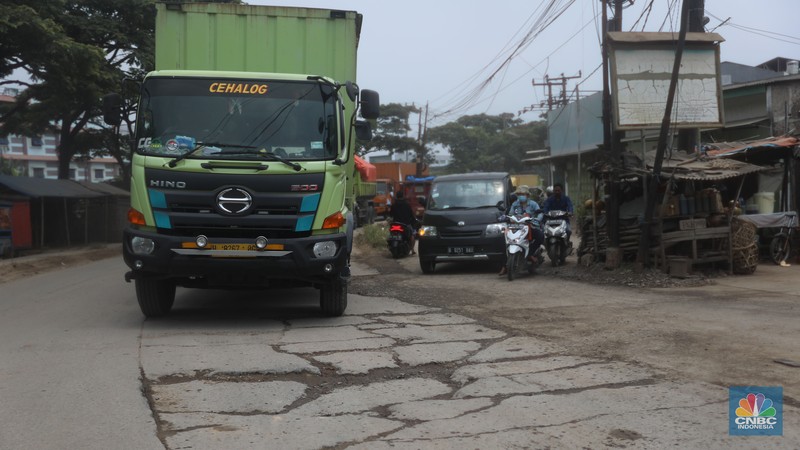 Sejumlah kendaraan melintas di jalan yang rusak di Kawasan Jalan raya Perancis Dadap, Tangerang Kamis, (22/9/2022). (CNBC Indonesia/Muhammad Sabki)