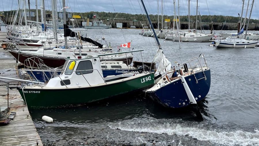 Sebuah perahu layar terdampar di sebelah kapal kecil setelah Badai Fiona berlalu di Shearwater, Nova Scotia, Kanada, Sabtu (24/9/2022). Sebelumnya, badai Fiona juga terjadi di Puerto Rico yang menghancurkan wilayah yang berada di bagian Timur Karibia tersebut. (REUTERS/Eric Martyn)