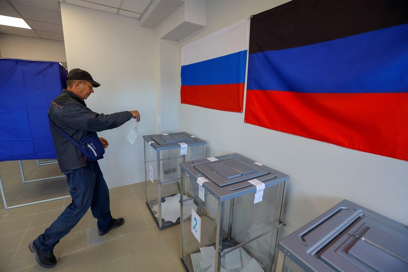 Penduduk lokal Valentina (90) menunggu sebelum menerima surat suara dari anggota komisi pemilihan, yang mengunjungi apartemen dengan kotak suara dan dokumen pada hari ketiga referendum tentang bergabungnya Republik Rakyat Donetsk (DPR) yang memproklamirkan diri ke Rusia, di Mariupol, Ukraina, Minggu (25/9/2022). (REUTERS/Alexander Ermochenko)