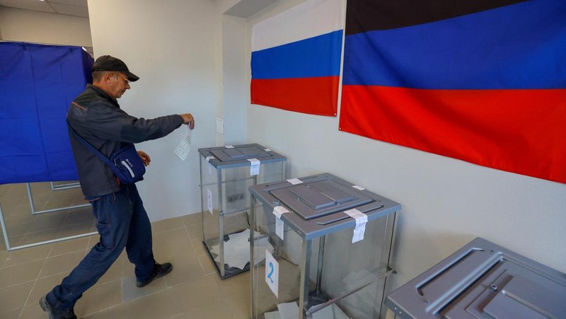 Penduduk lokal Valentina (90) menunggu sebelum menerima surat suara dari anggota komisi pemilihan, yang mengunjungi apartemen dengan kotak suara dan dokumen pada hari ketiga referendum tentang bergabungnya Republik Rakyat Donetsk (DPR) yang memproklamirkan diri ke Rusia, di Mariupol, Ukraina, Minggu (25/9/2022). (REUTERS/Alexander Ermochenko)