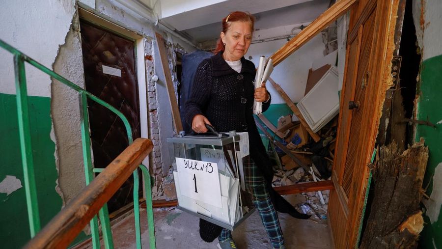Penduduk lokal Valentina (90) menunggu sebelum menerima surat suara dari anggota komisi pemilihan, yang mengunjungi apartemen dengan kotak suara dan dokumen pada hari ketiga referendum tentang bergabungnya Republik Rakyat Donetsk (DPR) yang memproklamirkan diri ke Rusia, di Mariupol, Ukraina, Minggu (25/9/2022). (REUTERS/Alexander Ermochenko)