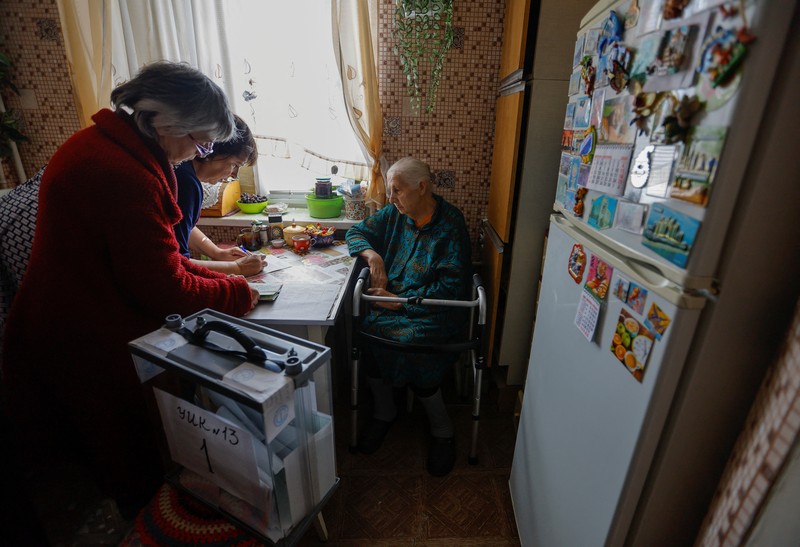 Pemungutan suara referendum tentang bergabungnya Republik Rakyat Donetsk (DPR) ke Rusia, di Mariupol, Ukraina Penduduk lokal Valentina (90) menunggu sebelum menerima surat suara dari anggota komisi pemilihan, yang mengunjungi apartemen dengan kotak suara dan dokumen pada hari ketiga referendum tentang bergabungnya Republik Rakyat Donetsk (DPR) yang memproklamirkan diri ke Rusia, di Mariupol, Ukraina, Minggu (25/9/2022). (REUTERS/Alexander Ermochenko)