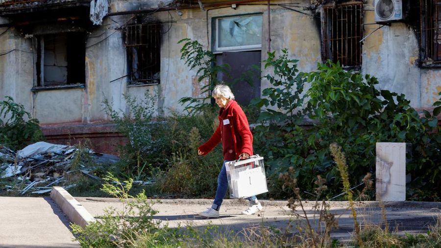 Penduduk lokal Valentina (90) menunggu sebelum menerima surat suara dari anggota komisi pemilihan, yang mengunjungi apartemen dengan kotak suara dan dokumen pada hari ketiga referendum tentang bergabungnya Republik Rakyat Donetsk (DPR) yang memproklamirkan diri ke Rusia, di Mariupol, Ukraina, Minggu (25/9/2022). (REUTERS/Alexander Ermochenko)