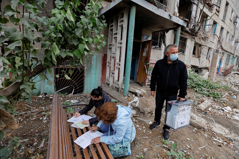 Penduduk lokal Valentina (90) menunggu sebelum menerima surat suara dari anggota komisi pemilihan, yang mengunjungi apartemen dengan kotak suara dan dokumen pada hari ketiga referendum tentang bergabungnya Republik Rakyat Donetsk (DPR) yang memproklamirkan diri ke Rusia, di Mariupol, Ukraina, Minggu (25/9/2022). (REUTERS/Alexander Ermochenko)