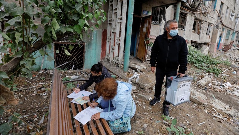 Penduduk lokal Valentina (90) menunggu sebelum menerima surat suara dari anggota komisi pemilihan, yang mengunjungi apartemen dengan kotak suara dan dokumen pada hari ketiga referendum tentang bergabungnya Republik Rakyat Donetsk (DPR) yang memproklamirkan diri ke Rusia, di Mariupol, Ukraina, Minggu (25/9/2022). (REUTERS/Alexander Ermochenko)