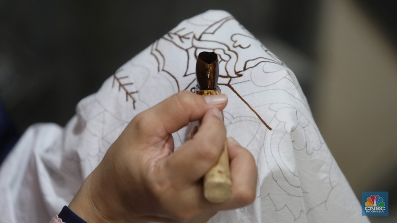 Pengrajin melakukan pencantingan saat proses pembuatan batik tulis di Batik Betawi Terogong, Cilandak, Jakarta, Senin (19/9/2022). Motif ondel-ondel pada batik Betawi Terogong menjadi yang paling banyak diminati konsumen baik lokal maupun mancanegara karena motif ini menampilkan identitas kental budaya Betawi. (CNBC Indonesia/ Andrean Kristianto)