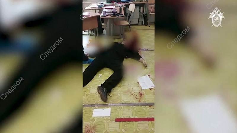 Polisi dan paramedis bekerja di lokasi penembakan di sekolah No. 88 di Izhevsk, Rusia, Senin (26/9/2022). Seorang pria bersenjata melakukan penembakan yang menewaskan 13 orang dan melukai 21 lainnya di sebuah sekolah di Rusia tengah. (AP Photo)