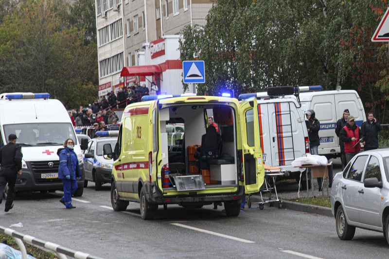 Polisi dan paramedis bekerja di lokasi penembakan di sekolah No. 88 di Izhevsk, Rusia, Senin (26/9/2022). Seorang pria bersenjata melakukan penembakan yang menewaskan 13 orang dan melukai 21 lainnya di sebuah sekolah di Rusia tengah. (AP Photo)