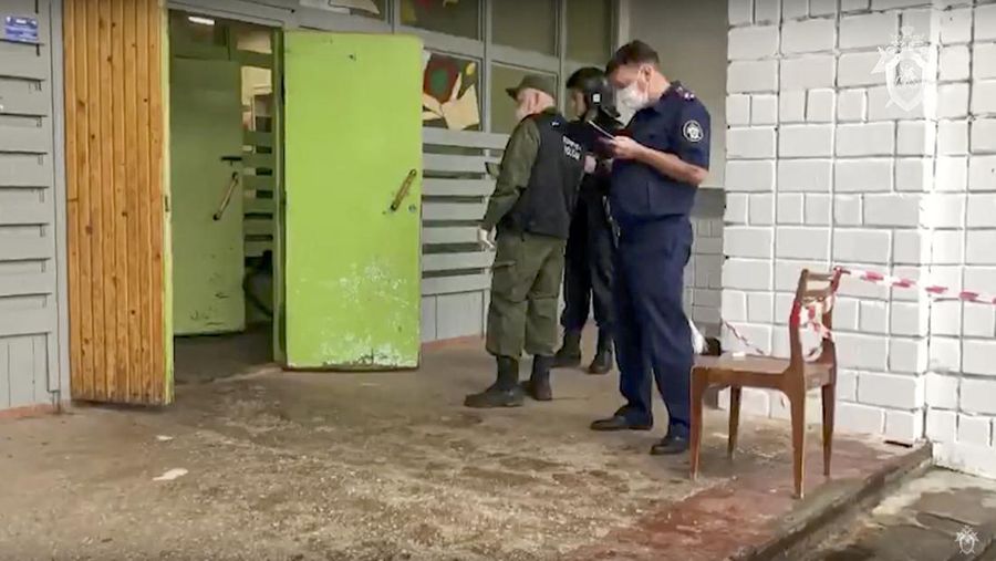 Polisi dan paramedis bekerja di lokasi penembakan di sekolah No. 88 di Izhevsk, Rusia, Senin (26/9/2022). Seorang pria bersenjata melakukan penembakan yang menewaskan 13 orang dan melukai 21 lainnya di sebuah sekolah di Rusia tengah. (AP Photo)