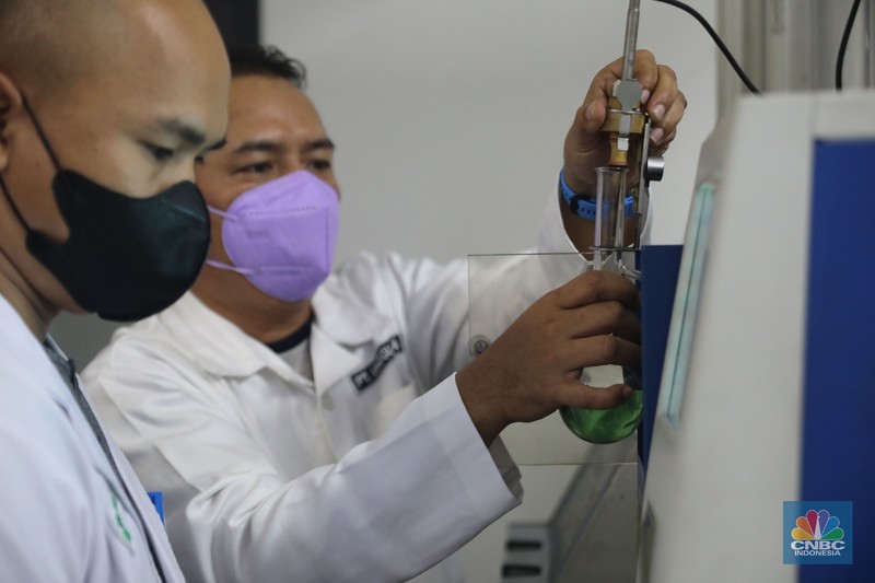 Analis menyiapkan sample untuk melakukan uji distilasi di ruang laboratorium Integrated Terminal Pertamina, Pelumpang, Jakarta, Selasa (27/9/2022). (CNBC Indonesia/ Muhammad Sabki)
